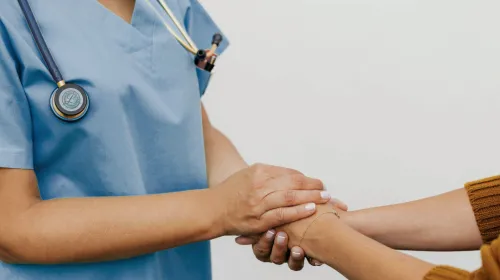 läkare håller patients händer